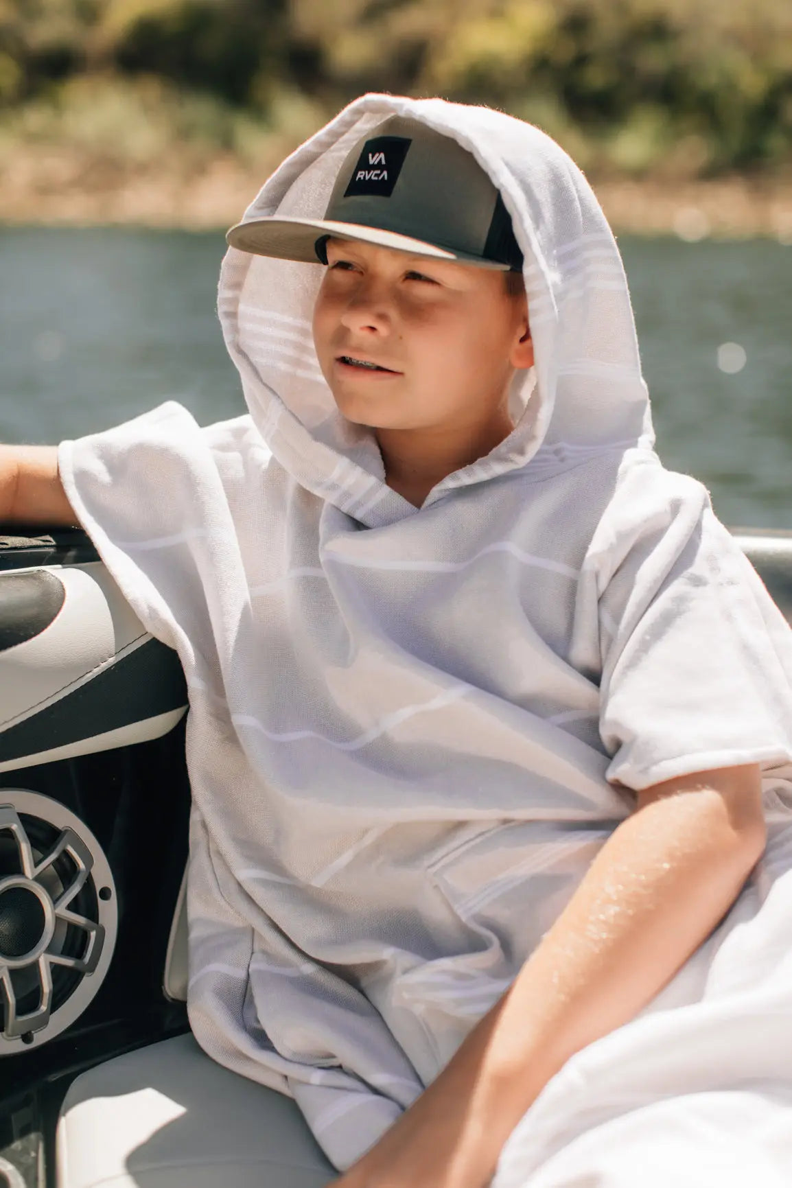 boy in surf boat wearing tan hooded towel turkish changing poncho 