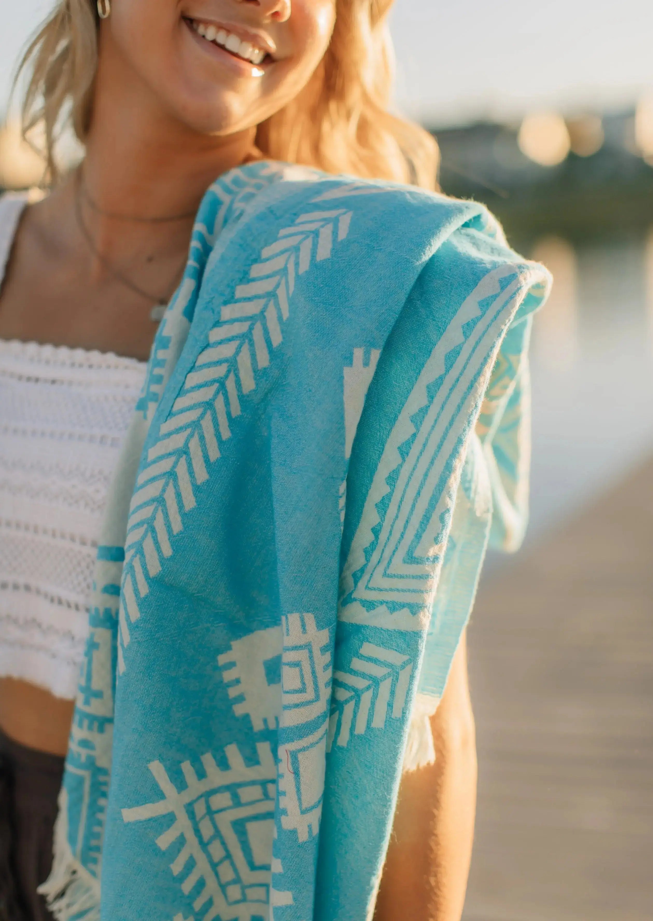 happy girl at lake with towel on shoulder teal blue turkish towel reversible pattern 