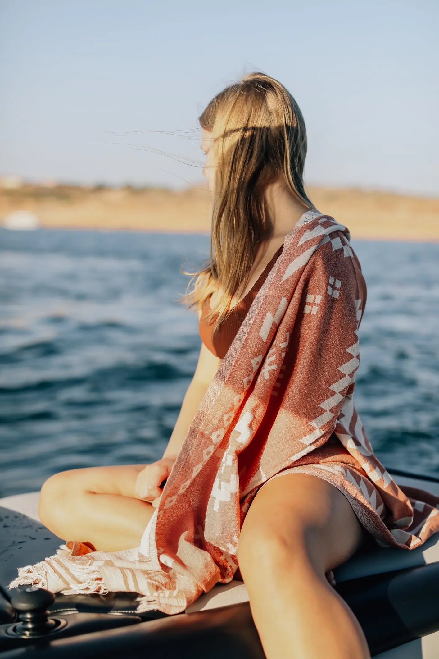 girl at lake on boat with towel over shoulder boating, beach towel in summer 