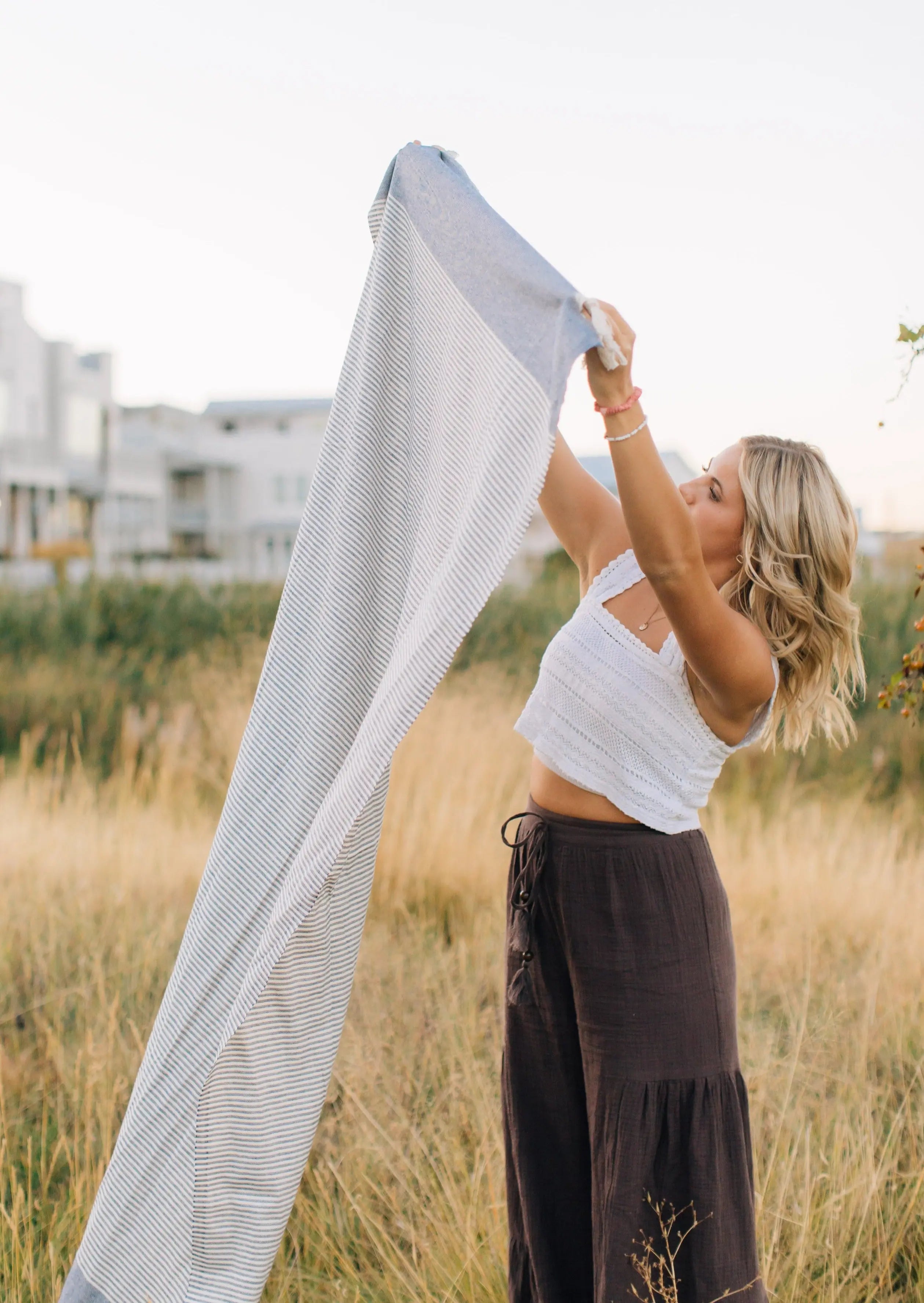 girl holding in the wind turkish towel with strips , oversized beach towel 